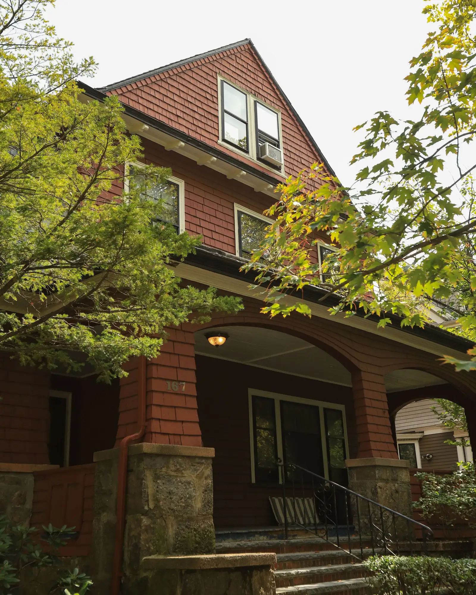Brick craftsman bungalow with a deep arched front porch and stone steps