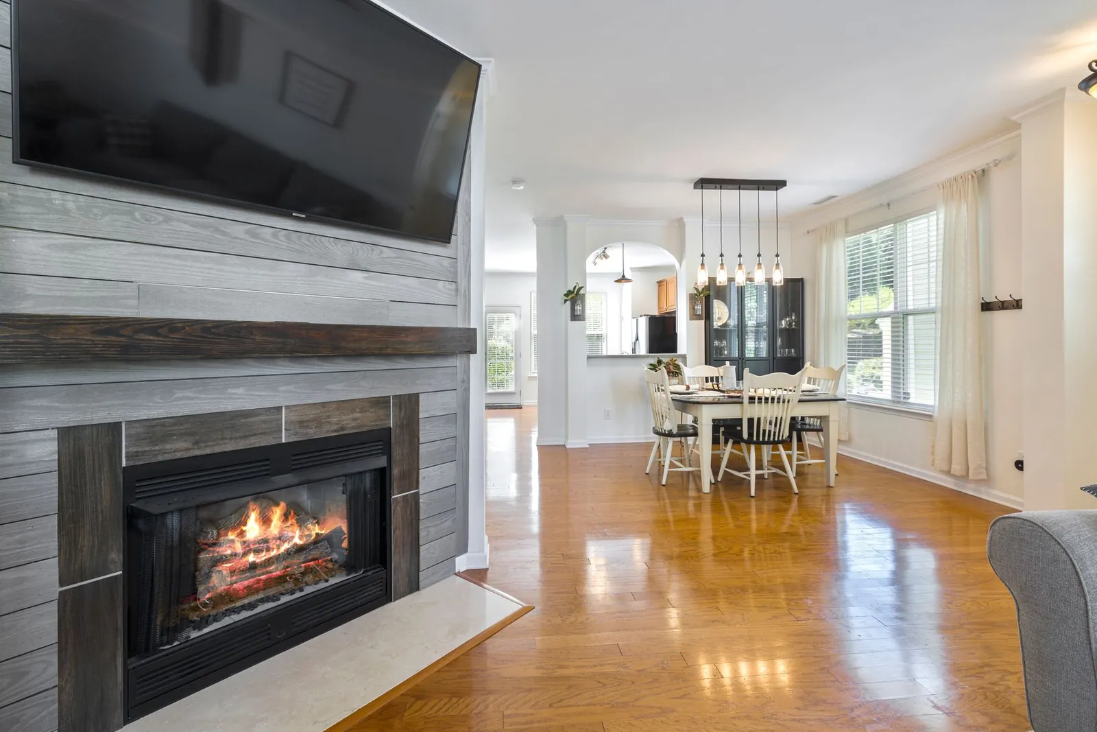 Glass-front fireplace insert with flames set in a gray plank surround